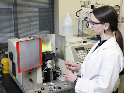 Photo of an NIU student conducting research in a lab.