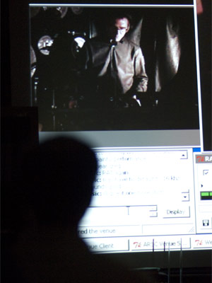 NIU percussion professor Greg Beyer (on screen and in silhouette) performs in a 2007 Alaskan concert from inside the NIU Music Building.