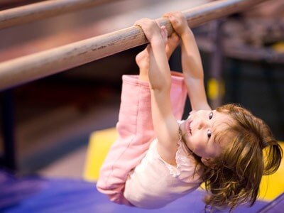 Photo of young girl on gymnastics parallel bar