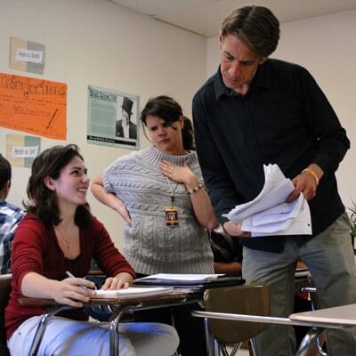 Fred Heuschel, who teaches humanities and media literacy at DHS, and his co-teacher speak with a student about her classwork.