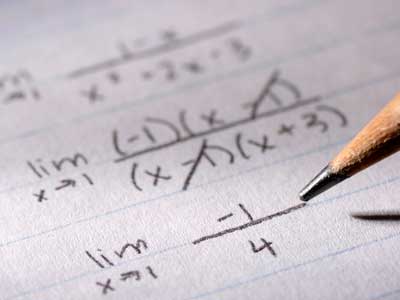 Photo of math problems on paper and pencil tip