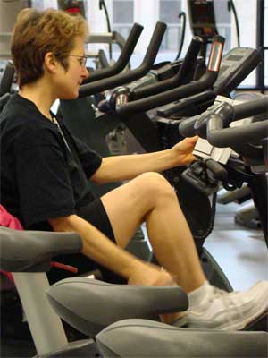 Photo of a woman on a stationary bicycle at the Rec Center.