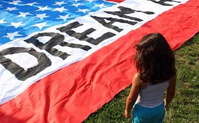 Photo of a young girl looking at a DREAM Act banner
