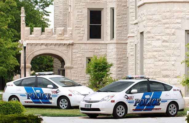 A photo of two NIU police cars – Toyota Prius models – parked outside Altgled Hall.