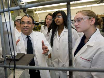 NIU chemist Narayan Hosmane, who is participating in the REU program, works with students in his lab.