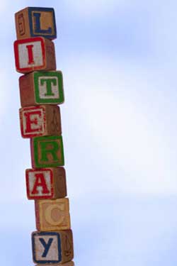 Photo of a stack of alphabet blocks spelling “literacy.”