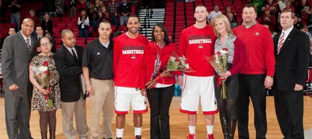 Men’s basketball seniors DeMarcus Grady and Tyler Storm pose with their families, Coach Mark Montgomery and Athletics Director Jeff Compher.