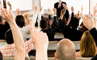Photo of people raising their hands in a meeting
