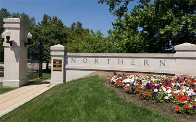 Summertime photo of NIU's front gates on Lincoln Highway
