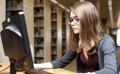 Photo of an NIU honors student using a computer at Founders Memorial Library.