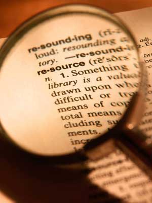 Photo of a magnifying glass over the word “resource” in the dictionary