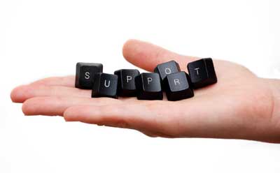 Photo of a hand holding computer keyboard keys spelling the word “SUPPORT”