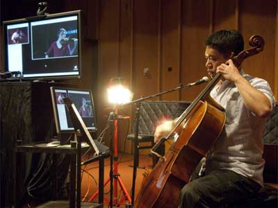 Cheng-Hou Lee performs via Internet2 for an audience in Philadelphia. He can see violinist Marjorie Bagley on the computer monitor.