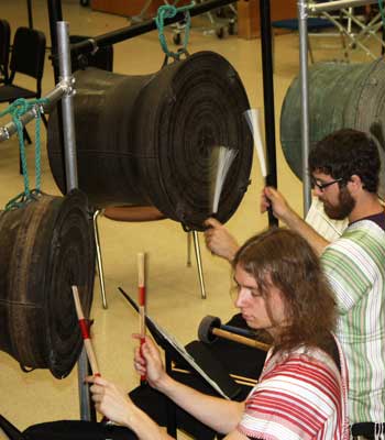 Students Lane Parsons (left) and Nick Fox rehearse School of Music professor Gregory Beyer’s composition “Five Pools” on antique bronze drums from Burma. The piece’s world premiere takes place this weekend during the International Burma Studies Conference at NIU.
