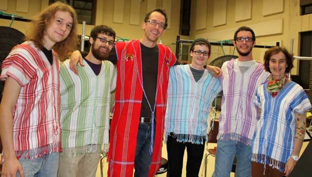 Associate music professor Gregory Beyer, center, and percussion students, from left, Lane Parsons, Nick Fox, Jonny Gifford and Brian Wach take a break from rehearsing to try on traditional Karen tunics from Burma that they will wear when playing Beyer’s piece Saturday night during the International Burma Studies Conference. The tunics were provided by Center for Burma Studies Director Catherine Raymond (right).
