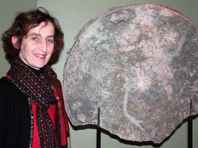 Center for Burma Studies Director Catherine Raymond, organizer of the International Burma Studies Conference at NIU this weekend, shows a fragment of an ancient bronze drum from Burma currently on display at the NIU Art Museum.