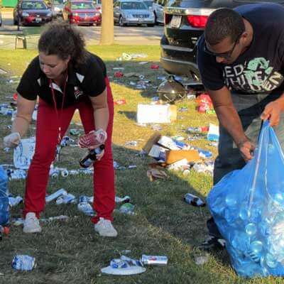 Volunteers pick up recyclables outside Huskie Stadium.