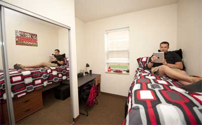 An NIU student relaxes in his room in the New Residence Hall.