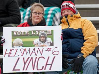 Photo of two NIU football fans with a "HEISMAN #6 LYNCH" sign