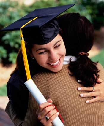 Photo of a graduate in cap and gown with diploma hugging mother