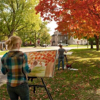 NIU art students paint outside the Music Building during class.