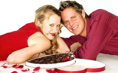 Photo of romantically involved couple with Valentine's Day heart-shaped box of chocolates