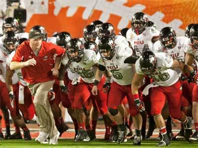 Coach Rod Carey leads the NIU Huskies onto the field at the 2013 Discover Orange Bowl.