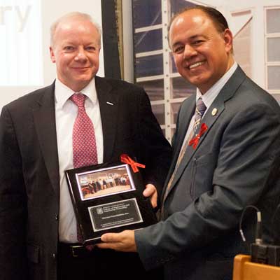 Promod Vohra, dean of the College of Engineering and Engineering Technology, celebrates with Nigel Blakeway, Omron CEO and president of the Omron Foundation.