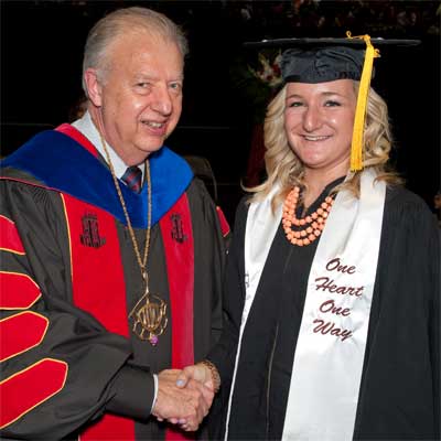 NIU President John G. Peters shakes hands with Grace Reynolds after she received her diploma May 11, 2013