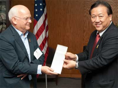 Welcome gift: Thai language professor John Hartmann accepts a grant for a Thai e-learning program from Thai Ambassador to the United States Chaiyong Satjipanon at a luncheon hosted by the Division of International Programs.