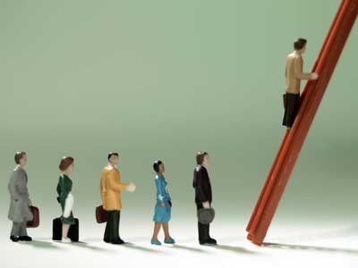 Photo of  toy figurines of “business people” climbing the corporate ladder.