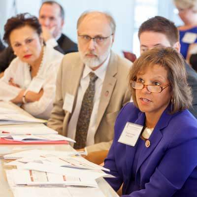 Congresswoman Robin Kelly (right) asks a question during Monday’s Research Roundtable. NIU President Doug Baker, along with Board of Trustees Chair John Butler (behind Kelly) and immediate past chair Cherilyn G. Murer (left) led the event.