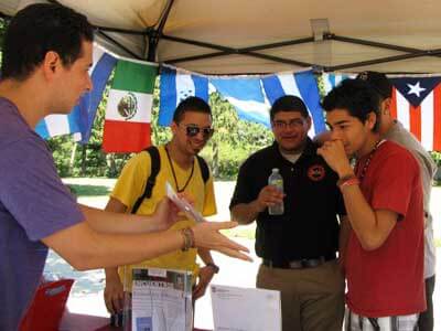 Southeast Asia’s 11 country flags decorate the Center for Southeast Asian Studies at last year’s annual Area Studies Open House while Victor Mendoza, left, graduate assistant for the Center for Latino and Latin American Studies (CLLAS), runs a Guess the Flags of Latin America game at the CLLAS tent.