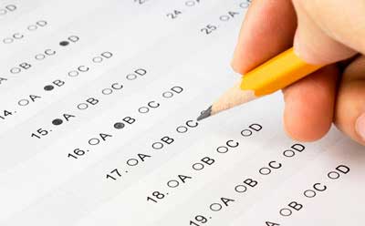Photo of a person taking a standardized test with a No. 2 pencil