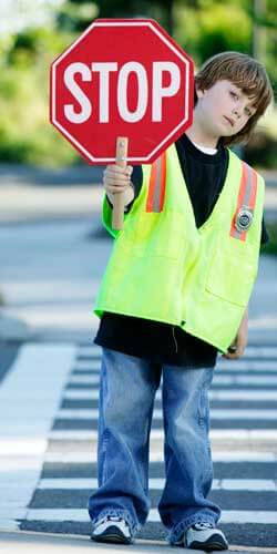 Photo of a young crossing guard with a stop sign