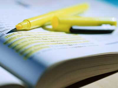 Photo of a yellow highlighter on an open text book