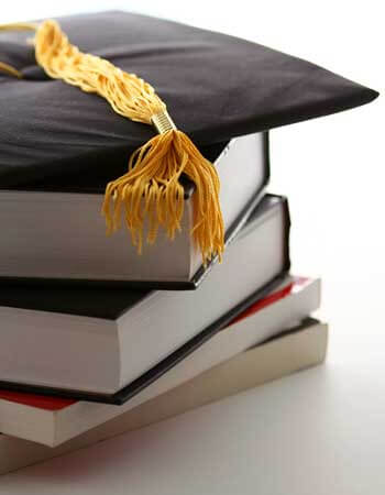 Photo of a mortar board and tassel on a stack of books