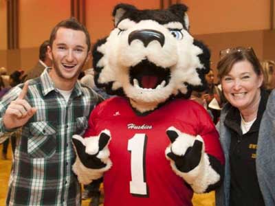Victor E. Huskie greets an admitted student and his mother.