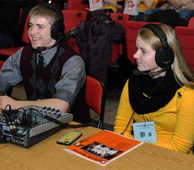 Sycamore High School student Jordyn Shultz (right) works at the broadcast table alongside DeKalb High School student Owen Smith.