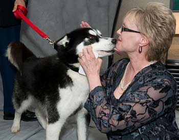 Mission rewards co-owner Karen Street with a kiss at the Red and Black alumni event.