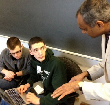 NIU Professor Dhiman Chakraborty (rights) talks with students Matthew Williams  (left) and Chase Pipes.