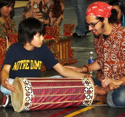 DeKalb middle-schooler Tony Un learns how to play the drum in the Balinese gamelan from NIU Gamelan Ensemble member Manuel Montalvo at Culture Fest 2013.