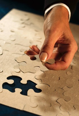 Photo of a hand putting in the final piece of a jigsaw puzzle