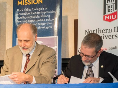 Presidents Doug Baker and Mike Mastroianni sign an agreement to allow students to apply NIU credits towards an RVC associate's degree.