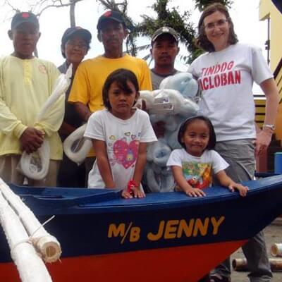 Katharine Wiegele poses in Tacloban City with boat recipient and fisherman Rodrigo Enico (far left) and his family during the boat blessing and handover in Tacloban City. Enico's motorboat was named after DeKalb resident and donor Jennifer Mescher, childhood friend of Wiegele. Enico's livelihood has always been fishing but until now he did not have a boat of his own. "It took Typhoon Haiyan for me to have my own boat," he said. 