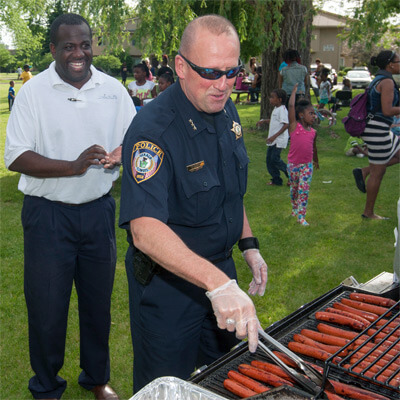 A City of DeKalb police officer grills hot dogs at the Camp Power barbecue.