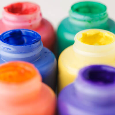 A photo of six jars of colorful paint