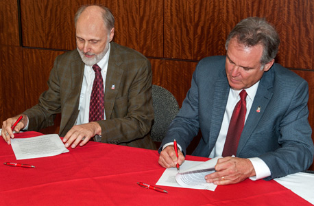 NIU President Doug Baker (left) and College of Lake County President Girard W. Weber sign an innovative reverse transfer agreement.