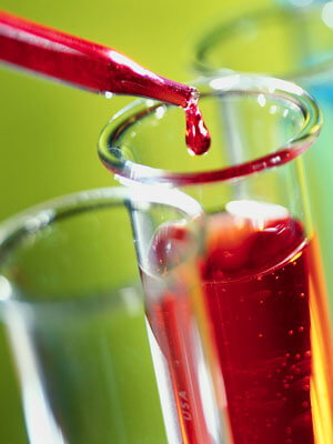 Photo of a red liquid being dropped into a beaker