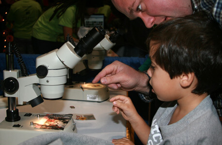 A boy looks into a microscope